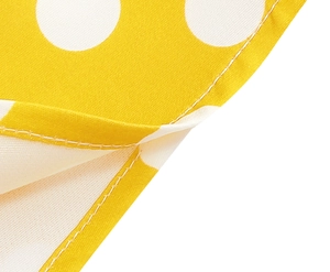 Detail of yellow polka dot cotton dress showing clean stitching and fabric texture