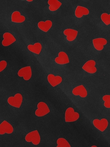 Close-up of black fabric with red heart patterns showing elegant textile texture