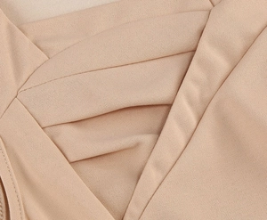 Détail du col en V croisé élégant et tissu en crêpe texturé de couleur abricot