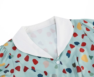 Detail of elegant white lapel collar and heart pattern print on light blue dress fabric