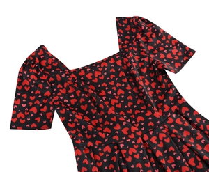 Détails du col carré et ourlet plissé sur robe noire d'été avec motifs cœurs