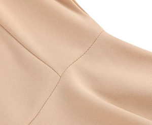 Gros plan détaillé des coutures et de la texture du tissu d'une robe d'été beige