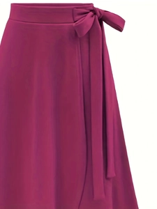 Détail d'une jupe portefeuille magenta foncé avec un nœud élégant et drapé à la taille
