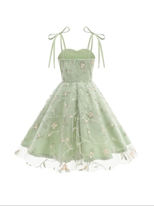 Détail de la robe en tulle vert sauge avec broderie florale et nœuds sur les épaules
