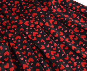 Vue détaillée d'une robe noire vintage avec imprimé cœurs et taille plissée élégante