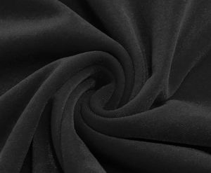 Detailed macro view of black velvet fabric with elegant spiral folds and silky texture