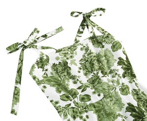 Close-up of adjustable bow straps and green floral print on vintage summer dress
