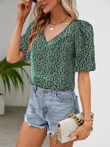 Detail of V-neck floral top with puff sleeves and green fabric texture in street style