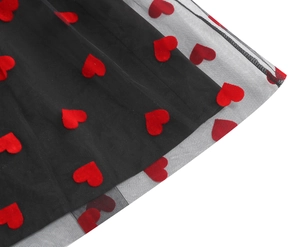 Detail of black mesh dress featuring textured red heart-shaped velvet embroidery patches