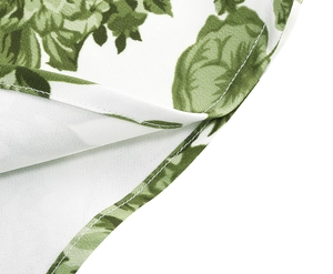 Detail shot of vintage green rose floral print on white fabric with neat edge stitching