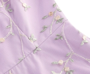 Close-up of elegant purple mesh embroidery with pink floral patterns on evening dress