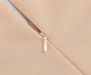 Détail de la texture du tissu beige avec une fermeture éclair invisible très soignée