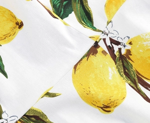 Close-up of high-quality woven fabric featuring vibrant yellow lemon and green leaf prints