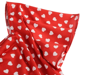 Detailed view of red fabric with white heart print and ruffled edge craftsmanship