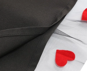 Detail of red heart embroidery on white mesh overlay of a black camisole dress