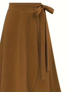 Détail de la jupe portefeuille caramel à taille haute avec un nœud papillon élégant