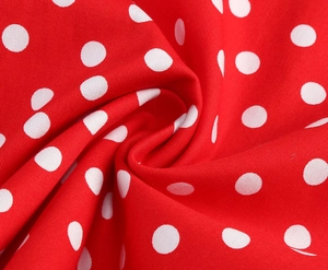 Gros plan du tissu rouge à pois blancs avec une texture détaillée pour robe d'été