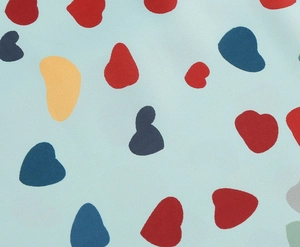 Close-up detail of heart floral print on light blue textured fabric of the vintage dress