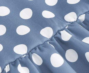 Macro view of blue polka dot dress fabric showing fine stitching and ruffle details