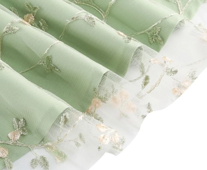 Détail de la robe de princesse vert clair avec broderie florale et couches de tulle doux