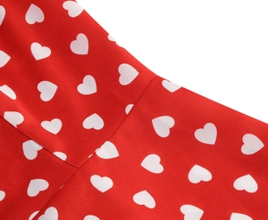 Close-up of red fabric with white heart pattern showing stitching and seam detail