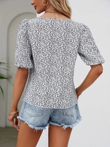 Rear view of floral puff sleeve blouse paired with frayed denim shorts for women