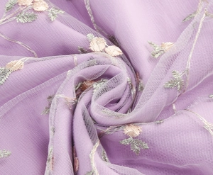 Close-up of lavender mesh fabric with intricate floral embroidery and delicate texture