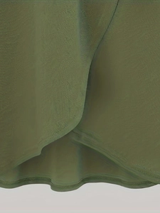 Gros plan détaillé sur la texture du tissu vert armée et les coutures superposées de la jupe