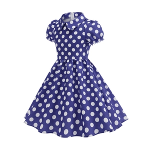 Detailed close-up of navy blue polka dot dress with Peter Pan collar and puff sleeves