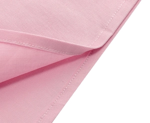 Detail shot of pink cotton dress fabric showing fine texture and double-stitched seams