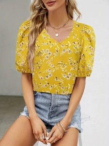 Detail of yellow floral V-neck top with puff sleeves and summer bohemian vibes
