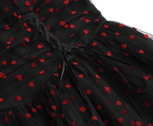 Dettaglio in rete nera con cuori rossi floccati e lacci per corsetto in raso nero