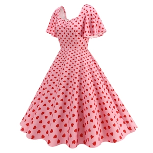 Detail view of the elegant square neckline and red heart patterns on pink dress
