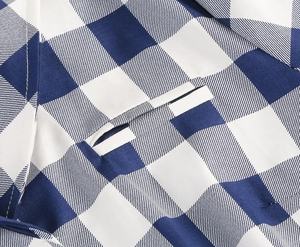 Primo piano del tessuto vichy blu e bianco con cuciture delle tasche e bordi bianchi