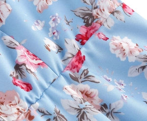 Close-up of light blue floral dress showing pink flower prints and pleated fabric texture