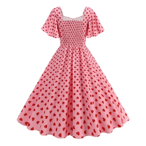 Detail of square neckline and flutter sleeves on a pink dress with red heart prints