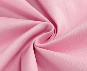 Detail of pink cotton-blend fabric texture showing smooth weave and soft finish