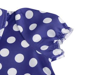 Detailed close-up of pleated short sleeves and white polka dots on blue cotton dress
