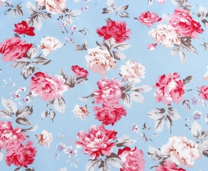Close-up of lightweight light blue floral fabric with red and pink rose patterns