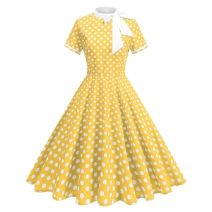 Détail d'une robe jaune à pois vintage avec col à nœud blanc et manches courtes