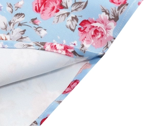 Close-up of floral print fabric with red roses and precise stitching on light blue base