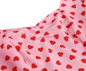 Detail of smocked square neckline on pink vintage dress with red heart print patterns