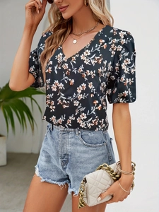 Detail of V-neck floral blouse with navy background and orange-white blossoms