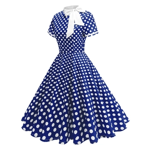 Détail de robe bleu marine à pois avec nœud blanc au col et coupe évasée rétro