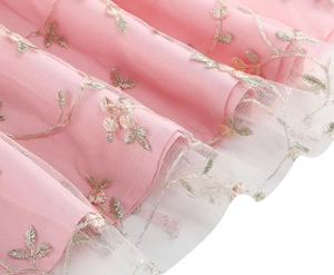 Détail d'une robe en tulle rose avec broderie de feuilles argentées et couches de résille