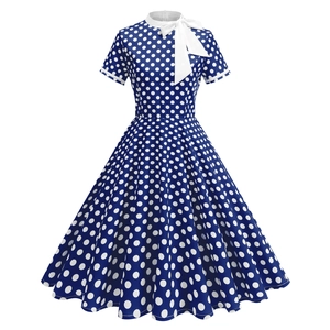 Détail d'une robe rétro bleu marine à pois avec nœud blanc et finitions classiques