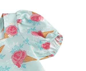 Close-up of girl's dress puff sleeve with pink rose and yellow ice cream print