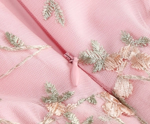 Détail d'une robe en tulle rose avec broderies de feuilles et fermeture éclair invisible