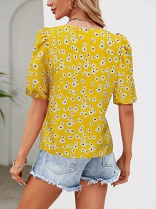Detail view of the puff sleeves and daisy floral print on the yellow summer blouse
