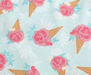 Close-up of floral ice cream print on light blue fabric featuring pink roses and cones